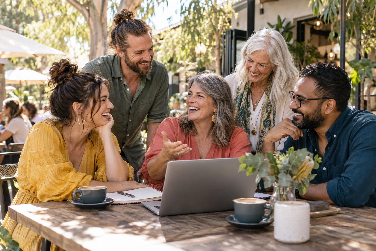 An illustrative scene of celebrants sharing ideas around a laptop